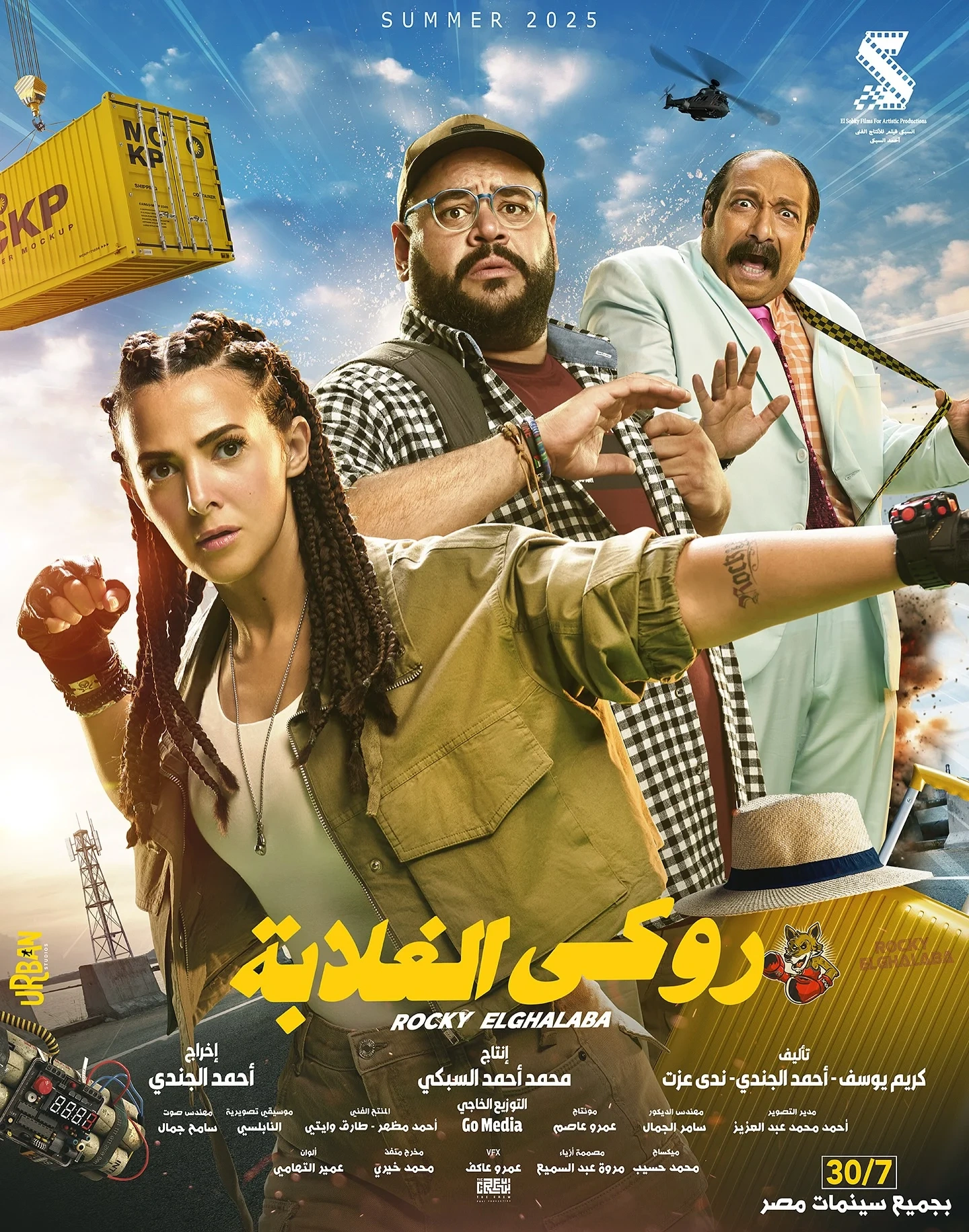 Movie poster for روكي الغلابة (Rocky Elghalaba) features three main characters: a woman with braids holding a helmet, a bearded man in glasses, and a man in a suit, with action scenes and shipping containers in the background.