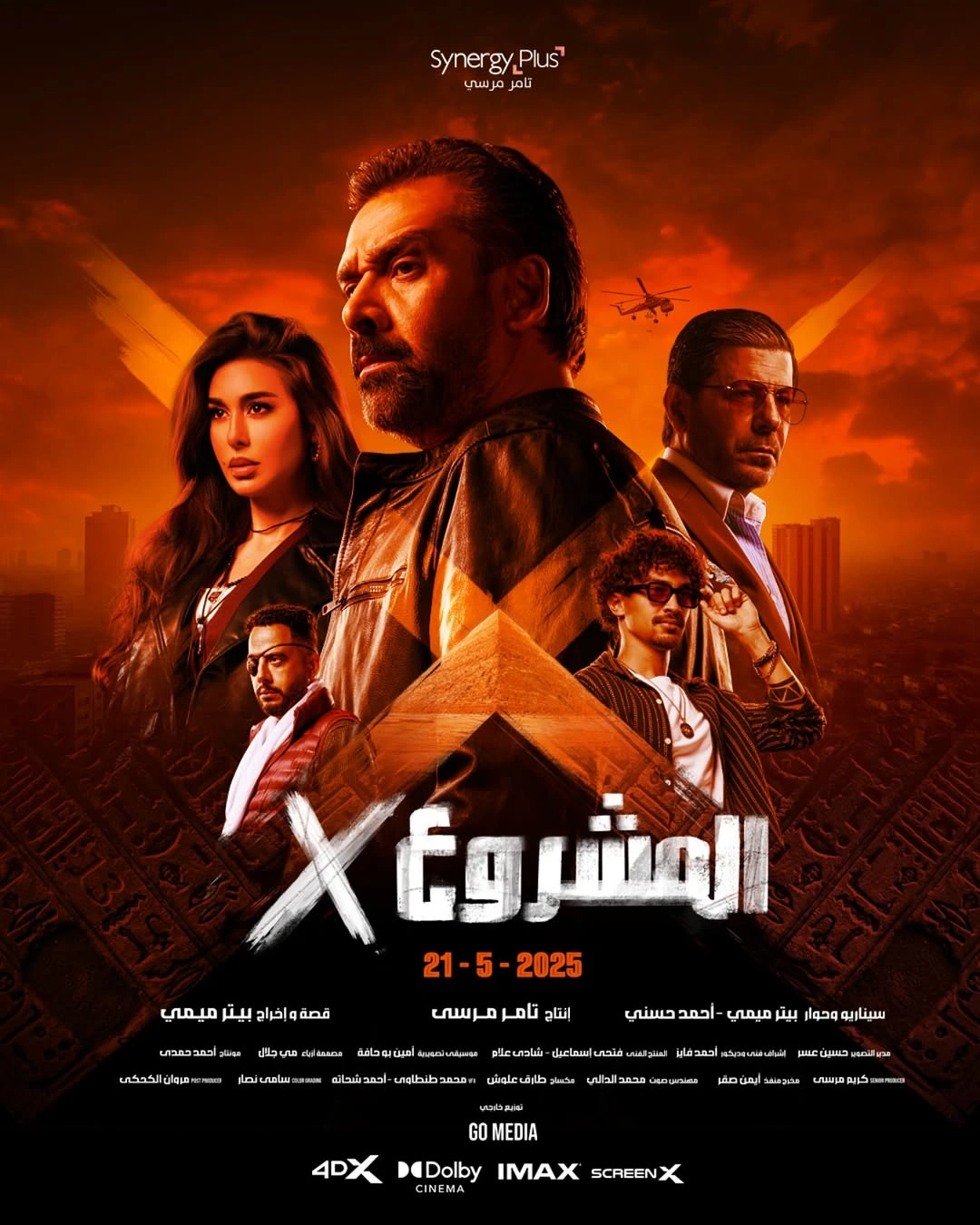 A dramatic Arabic movie poster features five intense-looking characters, with a pyramid and cityscape in the background. The title المشروع X and release date 21-5-2025 are prominent, alongside production credits and cinema formats.